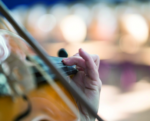 Foto einer Geige, die gerade gespielt wird.