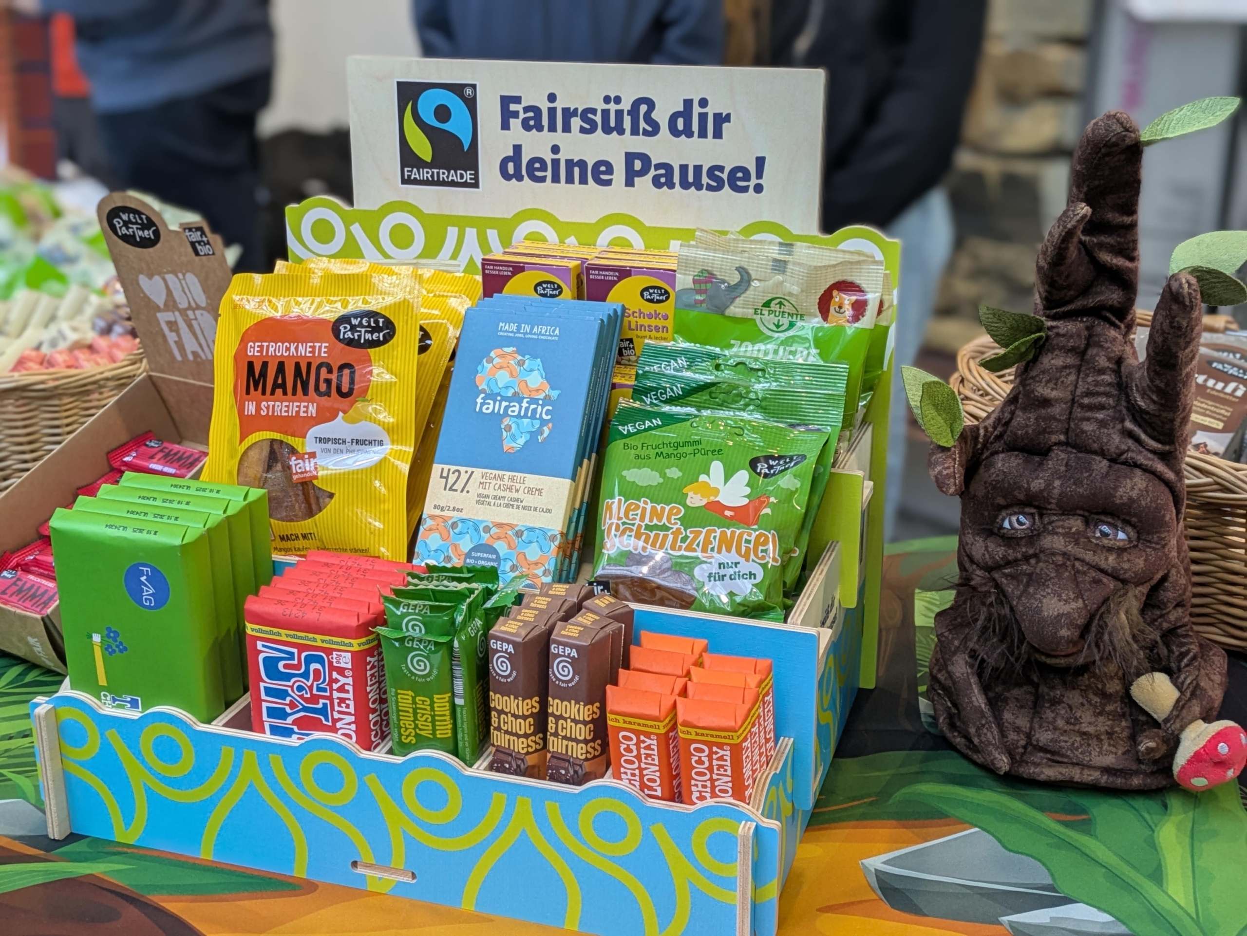Aufsteller mit fairen Süßigkeiten. Aufschrift "Fairsüß dir deine Pause".