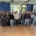 Schülerinnen und Schüler der Kursstufe, Lehrer und Ehemalige stehen als Gruppe in der Aula.