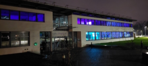 Schulgebäude mit blau erleuchteten Räumen zum blue Day