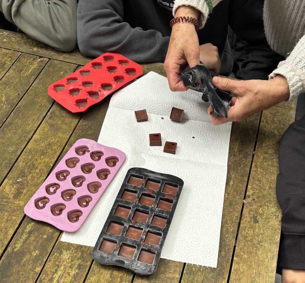 Zubereitung von Schokolade. Schokolade wird aus der Form gedrückt.