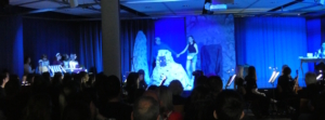 Schülerinnen und Schüler spielen bei blauem Licht Theater